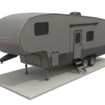 A gray fifth-wheel travel trailer with two axles is parked on a concrete pad, featuring exterior steps and multiple windows.