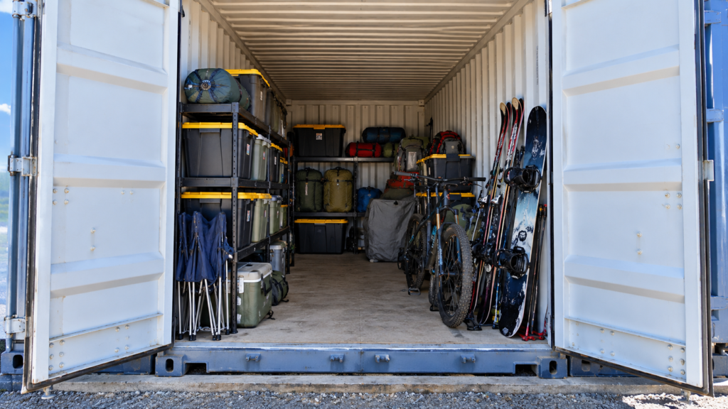 Organized seasonal equipment, labeled storage bins, bicycles, and outdoor gear inside a drive-up storage unit.