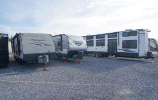 RVs and travel trailers parked on a gravel parking area at SteelSafe Hamburg, Pennsylvania.
